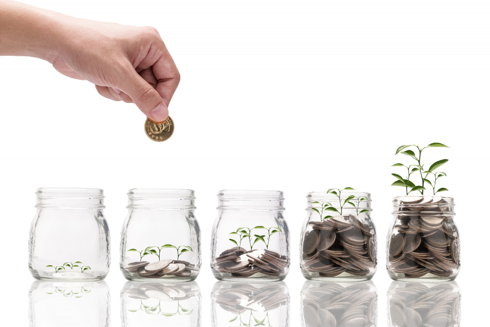 Zdjęcie oszczędzania z udziałem procentu składanego jako kilka słoików z monetami.